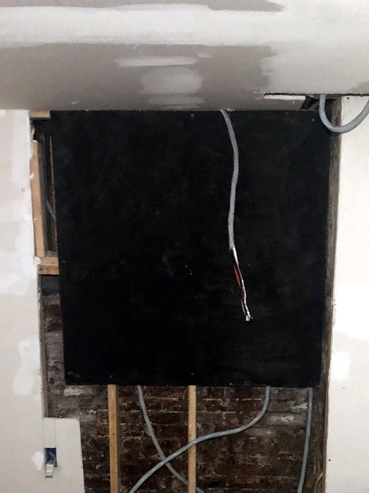 Bare mounting board with loose service cables before the new electrical panels were installed