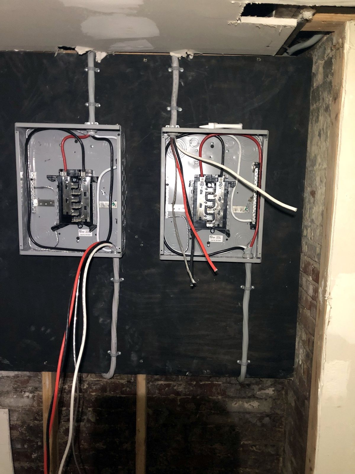 Two new electrical panels wired with feeders landed and cables neatly strapped